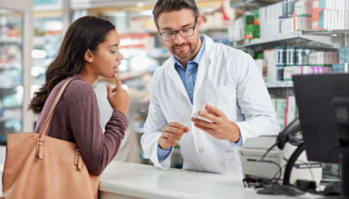 Woman at pharmacy counter asking about side effects